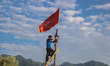 A Kashmiri Shiite Muslim man installs a religious flag atop a pole on the first day of the...