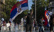 A young man with a Serbian flag stands in the fountain at Slavia Square in Belgrade, Serbi...