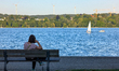A woman relaxes on benches at Lake Starnberg in Starnberg, Upper Bavaria, Bavaria, Germany...