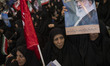 A veiled Iranian mourner holds a portrait of Iran's Supreme Leader, Ayatollah Ali Khamenei...