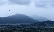 A bird takes flight against the hilltops being lashed with rain surrounding Kathmandu Vall...