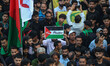 A Kashmiri Shiite Muslim mourner holds a placard that reads ''Free Palestine'' during a Mu...
