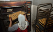 A worker checks the ripeness of an apple-flavored cake at a small and medium-sized enterpr...