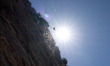 A spider and a web are seen against the sun next to a rock on Vagia beach on the island of...