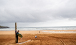 A surfer cleans his surfboard at the beach's shower in Cantabria, Spain, on May 26, 2025. 