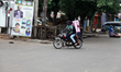 A commercial motorcyclist rides towards a campaign banner as Lagos State conducts an elect...