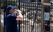A man drinks water and wears a hat to protect from the sun in the center of Athens, Greece...