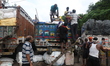 Labourers load sacks of consumer goods onto supply trucks at a wholesale market in Kolkata...