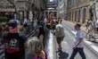People walk near a tram running along Augusta Street in the Baixa district of Lisbon, Port...
