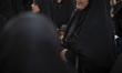 A young veiled Iranian girl looks on while participating in a ceremony to mark the memory...