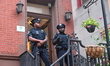 NYPD police officers work at the crime scene and prevent entry to the building where the s...