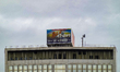 An illuminated E.ON billboard is mounted on the rooftop of a commercial building in centra...