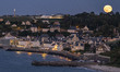 The full Sturgeon moon rising over the historical WWII D-Day town Arromanches with the rem...