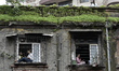 People watch the procession from windows and the roof of an old building as devotees trans...