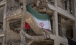 An Iranian flag hangs on a building targeted during Israeli attacks on a residential area...