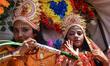 A young Hindu boy and girl, dressed as Lord Krishna and Radha, take part in the celebratio...