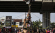 People climb during a greasy pole climbing race locally known as 'Panjat Pinang' to mark t...