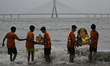 Volunteers carry idols of the Hindu god Ganesha into the Arabian Sea for immersion in Mumb...