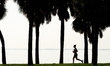 A woman runs at sunrise along the shoreline in St. Petersburg, Florida. Clear skies start...