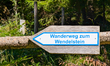 A wooden sign reading ''Wanderweg zum Wendelstein'' (Hiking trail to Wendelstein) marks th...
