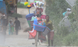 A cycle vendor walks in a dusty street to sell their product to customers in Lalitpur, Nep...