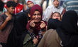 Palestinians mourn by the bodies of relatives killed in Israeli strikes in Gaza City, Pale...