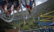 Young Iranian women sit on a reverse bungee at GMAX Adrenaline Park in the Namakabrud town...