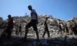 Palestinians check the rubble of a building called the Al-Ghafri Tower in the Rimal area o...