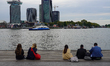 People sit by the waterfront as ferries cross the IJ River in Amsterdam, Netherlands, on S...