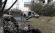 A man cuts down a tree damaged by Russian shelling on the grounds of the Salvation Church...