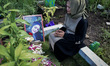 Siti Mardiyah prays at the grave of her daughter Mita Maulidya, one of the 135 victims of...