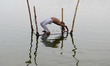 An indian hindu devotee performs yoga after taking a holy dip at Sangam,confluence of Rive...