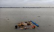 Devotees immerse the idol of Goddess Durga into the Ganges River on the last day of the Du...