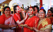 Indian married women apply vermilion on each other's faces during 'Sindoor Khela' before t...