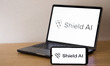 The Shield AI logo appears on a smartphone screen and on a laptop computer screen in this...