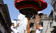 Nepali Hindu devotees spin the upside-down chariot of the Hindu god Satyanarayan during th...