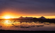 The sun sets behind the Sierra Buttes as birds return to recently harvested and flooded ri...