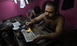 Goldsmiths work on crafting gold ornaments at a workshop ahead of Dhanteras, a Hindu festi...