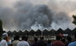 People gather as a fire breaks out in the cargo section of Hazrat Shahjalal International...