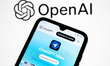 The ChatGPT Atlas website appears on a smartphone screen, and the OpenAI logo displays as...