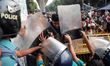 Protesters attempt to push through a police barricade as law enforcement officers block th...