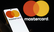 The Mastercard logo is displayed on a mobile phone with the company's branding seen in the...