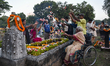 A physically challenged old woman on a handicapped tricycle with her family members prays...