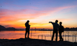 People enjoy the vibrant sunset by the Brahmaputra riverside, capturing photos and moments...