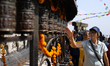 A tourist spins the prayer wheels while circumnutating the Swayambhunath Stupa, a UNESCO W...