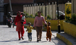 Nepali children, guided by their parents, arrive at an inoculation center in Kathmandu, Ne...
