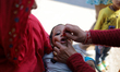 A Nepali health worker administers the Oral Polio Vaccine (OPV) to a Nepali child at an in...