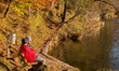Hikers rest by the clear water of Lake Hechtsee, surrounded by autumn foliage and the Bran...