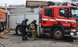 An employee of the Ukrainian State Emergency Service helps a rescuer put on a ballistic ve...