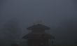 Nepali men jog around a temple on a foggy winter morning in Lalitpur, Nepal, on November 1...